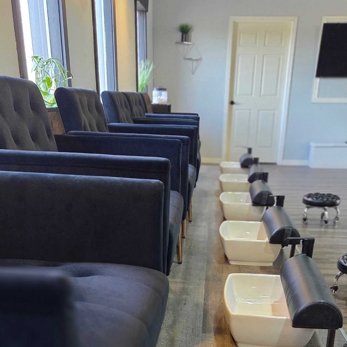 Pedicure chairs and footbaths in a modern spa setting.